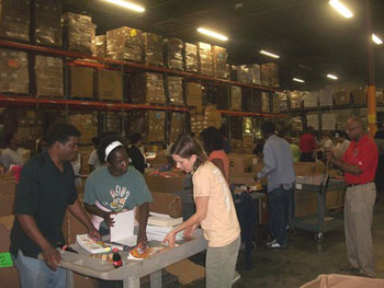 Two Americorps volunteers ask for the input of Books For Africa staff member Jennifer Duncan.