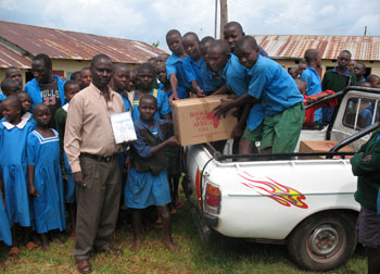 Students at Borangi Primary School in Kenya and their teacher unload their new BFA books provided by MKIDA and MoneyGram.