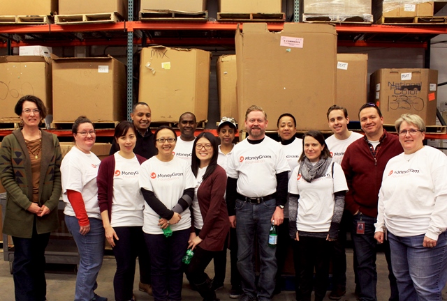 Moneygram International employees volunteer at the Books For Africa MN Warehouse
